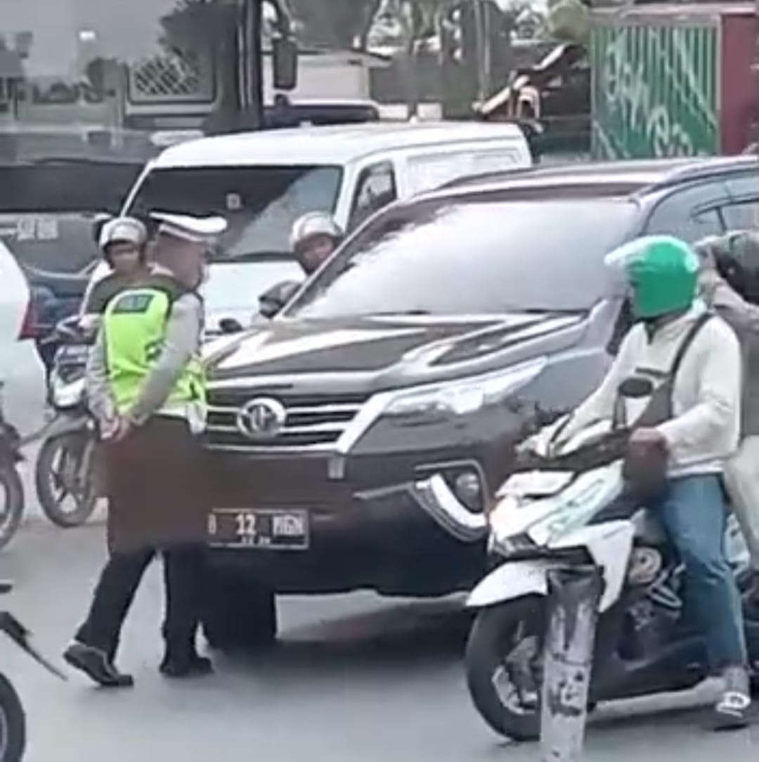 Seorang pengemudi mobil Pajero ngegas mau menerobos anggota Polantas yang memberhentikannya di simpang Cengkareng, Jakarta Barat pada Senin (20/3).